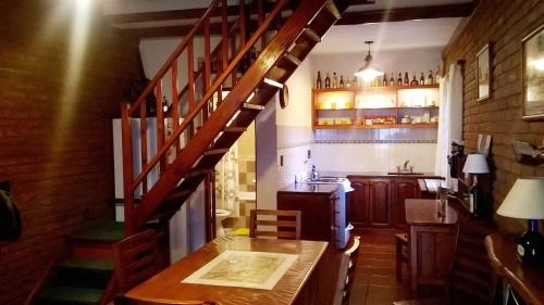 a kitchen with a wooden table and a wooden staircase at Cabañas El Maiten in San Clemente del Tuyú