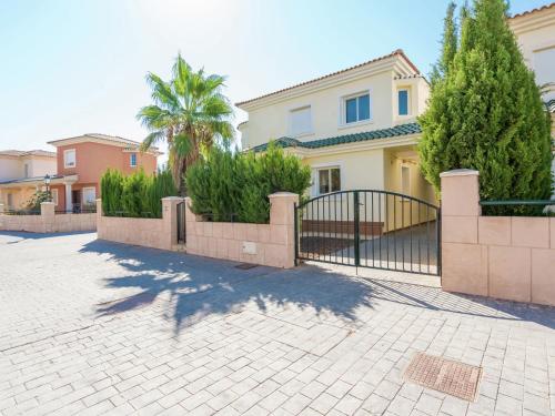 a house with a gate and a palm tree at Belvilla by OYO Villa Mosa Claire in Baños y Mendigo