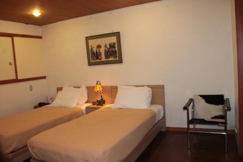 una habitación de hotel con 2 camas y una lámpara en Borgen en Funabashi