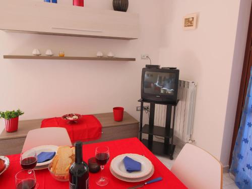 sala de estar con mesa y TV en Belvilla by OYO Giammy, en Acqualagna