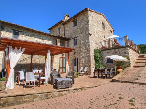 een patio met tafels en stoelen en een gebouw bij Belvilla by OYO Ginestrilo in Assisi