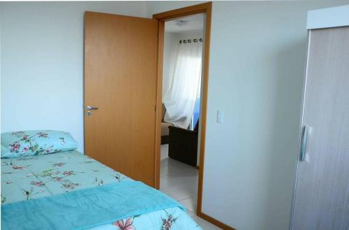 1 dormitorio con 1 cama y puerta al baño en Apartamento linda vista para o mar Penha Parque Beto Carrero, en Penha
