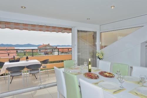 a dining room with a table and a balcony at Villa Dalmatina Zadar mit Pool in Zadar