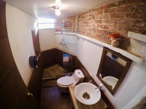 a small bathroom with a sink and a toilet at Kaena Point Hostel in Guatemala