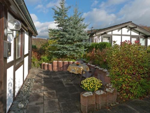 a garden with a table and a christmas tree at Holiday home on Lake Henne with terrace in Meschede