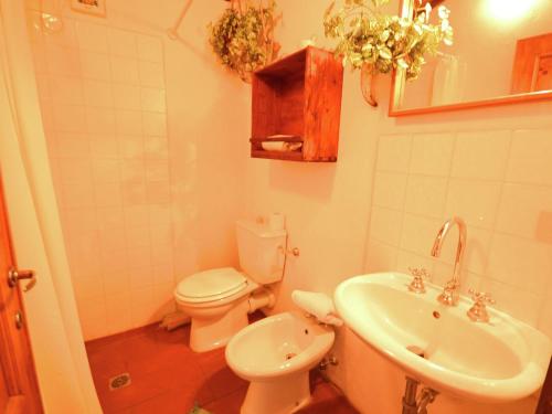 a bathroom with a white toilet and a sink at Olivi - Tutto in San Quirico