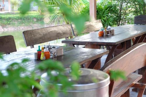a wooden picnic table with drinks on it at Khwanruen Fishing Resort in Ban Chang