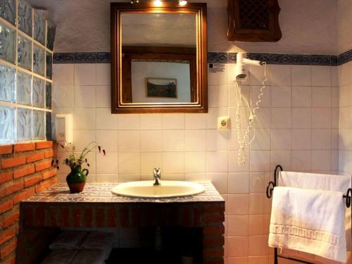 a bathroom with a sink and a mirror at Rural Farmhouse in Valencia de Alc ntara with Pool in La Borrega