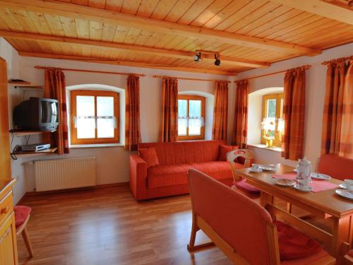 a living room with a red couch and a table at Lovely Holiday Home in Viechtach near the Forest in Viechtach