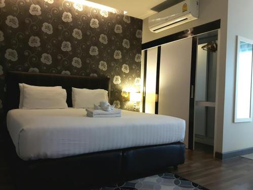 a bedroom with a bed with a teddy bear on it at Romyen Garden Place in Nakhon Ratchasima