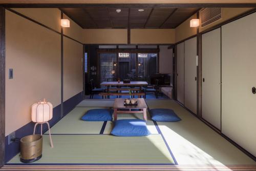a meditation room with a table and blue mats at Yoitsubaki Machiya House in Kyoto