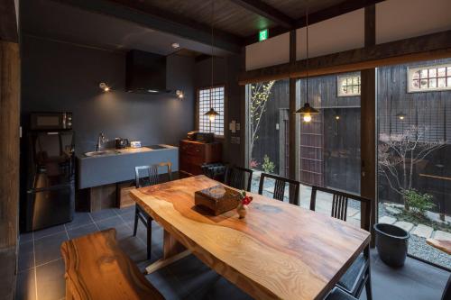 a kitchen with a wooden table in a room at Yoitsubaki Machiya House in Kyoto
