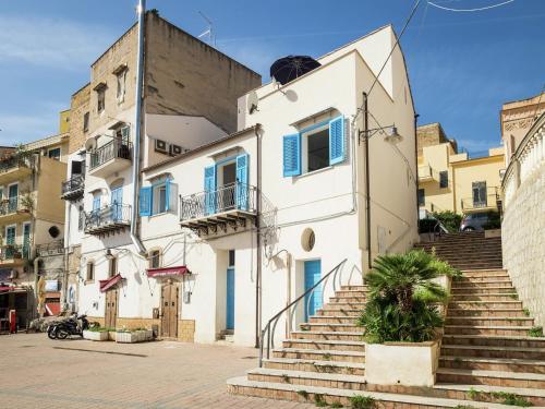 a white building with blue windows and stairs at Holiday home in Santa Flavia with terrace in Santa Flavia