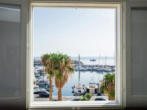 a window with a view of a marina with boats at Holiday home in Santa Flavia with terrace in Santa Flavia