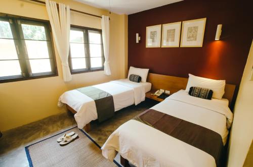 um quarto de hotel com duas camas e duas janelas em Lilu Pai em Pai