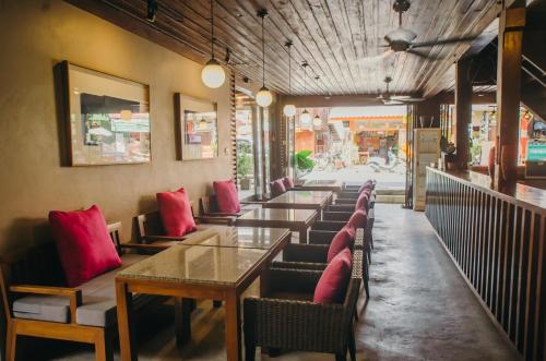 a row of tables in a restaurant with red pillows at Lilu Pai in Pai