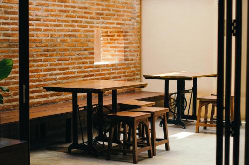 a row of tables and stools in front of a brick wall at Lilu Pai in Pai