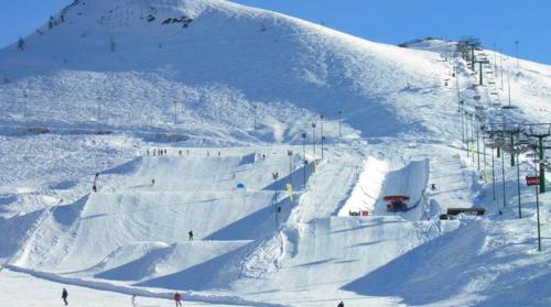 a snow covered slope with people skiing on a ski lift at Agriturismo La Dimora Del Contadino in Mondovì