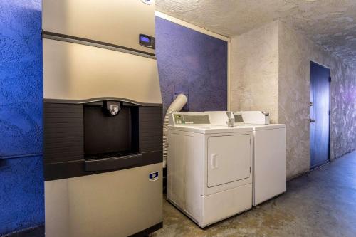a laundry room with a washing machine and a tv at Motel 6-Redlands, CA in Redlands