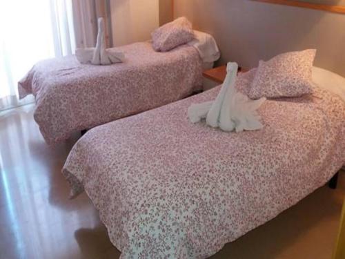 two beds with stuffed animals on them in a room at Hotel Cosmos Tarragona in Tarragona