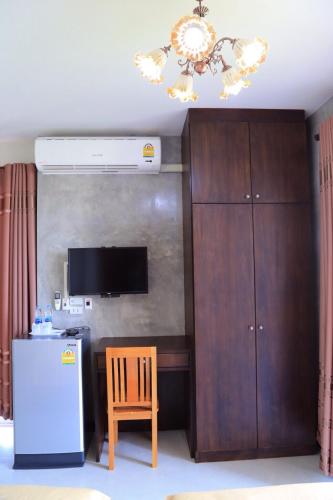 a room with a refrigerator and a chair and a chandelier at Nava Resort in Nakhon Nayok