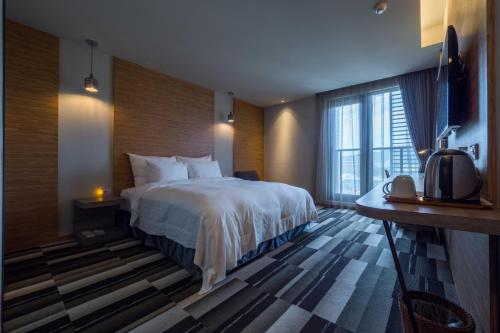 Postel nebo postele na pokoji v ubytování Watermark Hotel Kaohsiung Main Station