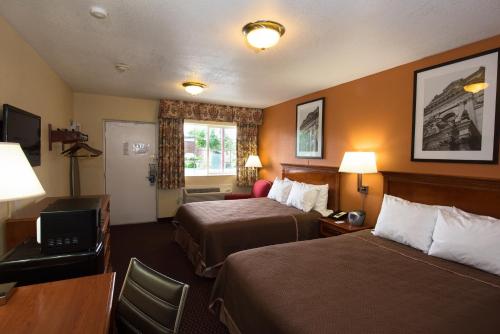 グローブシティにあるGrove City Travel Innのベッド2台とテレビが備わるホテルルームです。