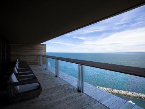 a balcony with chairs and a view of the ocean at Hotel New Awaji in Sumoto