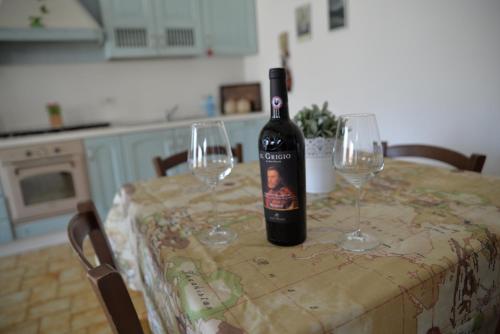 a bottle of wine sitting on a table with two wine glasses at Volta Como Lake apartament in Brunate