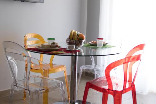 a dining room table with four chairs and a plate of food at Alludo Aparthotel b&b in Agrigento