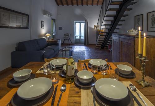 a dining room table with plates and glasses on it at Casa Vacanze Le Fornaci in Laterina