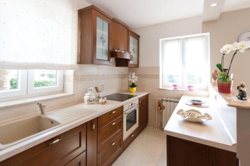 a kitchen with wooden cabinets and a sink at Apartments Silvia in Poreč