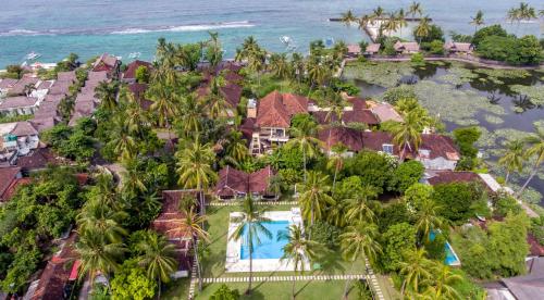 an aerial view of a resort with a pool and palm trees at The Forty Eight Resort Candidasa in Candidasa