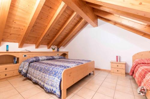 a bedroom with two beds and wooden ceilings at RESIDENCE-HOTEL CIMBRO in Mezzaselva