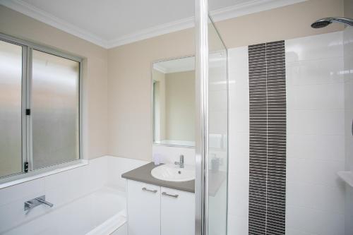 a white bathroom with a sink and a shower at Indian Ocean Retreat in Alkimos