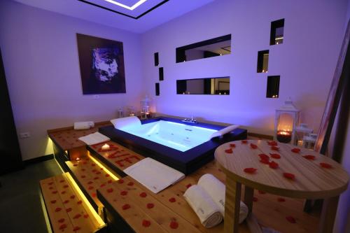a room with a large tub with a table in it at Hotel Delta Premium in Durrës