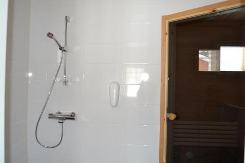 a shower with a shower head on a wall at Ruoke Holiday Village in Kesälahti