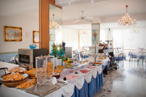 uma fila de buffet com comida nas mesas numa sala em Hotel Sanremo em Caorle