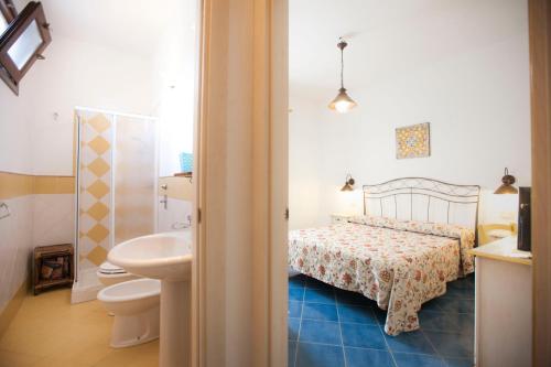 bagno con letto, servizi igienici e lavandino di A' Cavalera a San Vito lo Capo