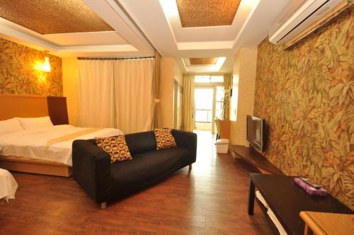 a hotel room with a bed and a couch at 青禾溫泉家民宿 in Jiaoxi