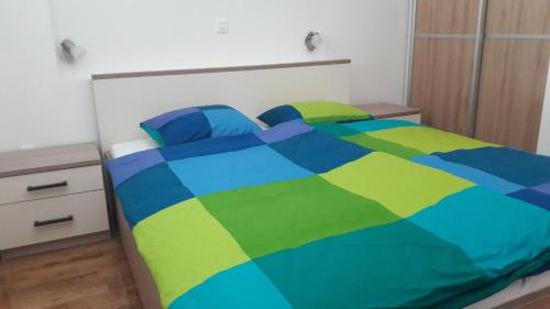 a bed with a colorful comforter in a bedroom at Apartment Lebedina in Kaštela