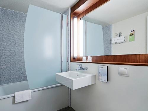 y baño con lavabo y espejo. en Campanile Aix-En-Provence Est - Meyreuil, en Meyreuil