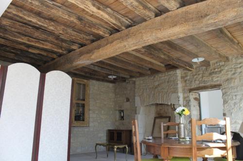 a living room with a table and a stone wall at Charmante Maison Pierres 1768 in Polisy