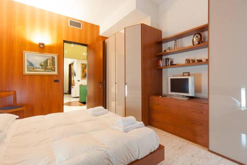 - une chambre avec un grand lit et une télévision dans l'établissement apartament Deluxe Quattro Spade, à Vérone