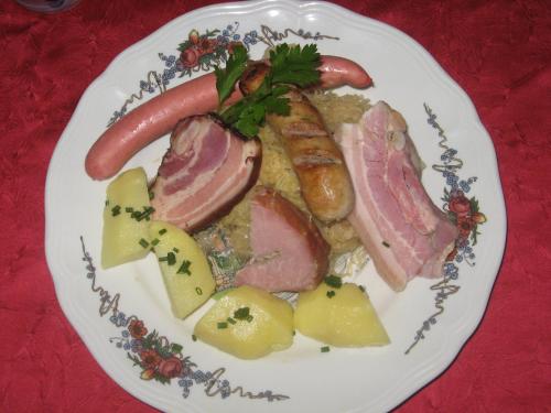 a plate of food with meats and vegetables on a table at La Couronne à Wissembourg in Wissembourg