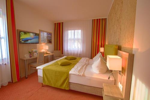 a hotel room with a bed and a desk at Falk Seehotel Plau am See in Plau am See