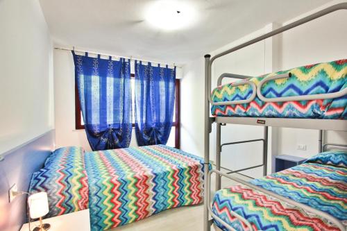sypialnia z dwoma łóżkami piętrowymi i oknem w obiekcie Condominio Libeccio w Lignano Sabbiadoro