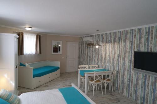 a hotel room with a bed and a table and a bedroom at Barackvirág Vendégház in Tihany