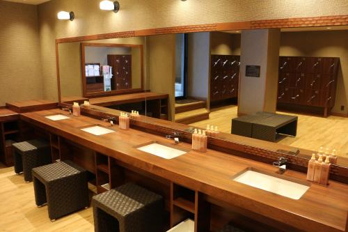 a large bathroom with a large mirror and sinks at Infinito Hotel and Spa in Shirahama