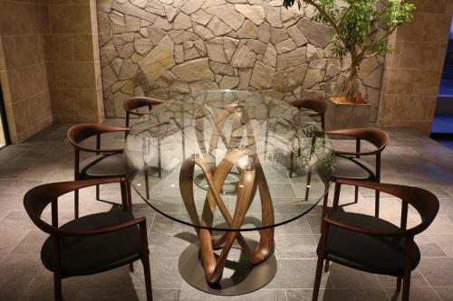 a glass table with a pair of chairs around it at Infinito Hotel and Spa in Shirahama